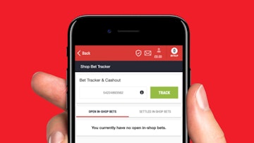 My Betting Sites expert holding i Phone displaying Ladbrokes The Grid bet tracker