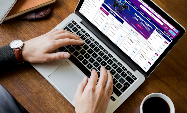 A man using the topsport betting website on a mac laptop computer