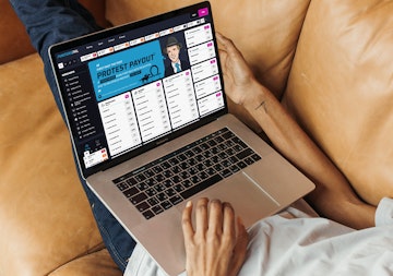 Man lying on a couch with a macbook pro using Punters Pal to place a bet