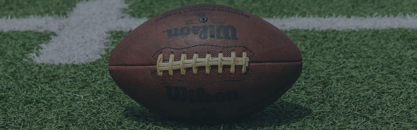 NFL betting sites header image showing Wilson football on grass